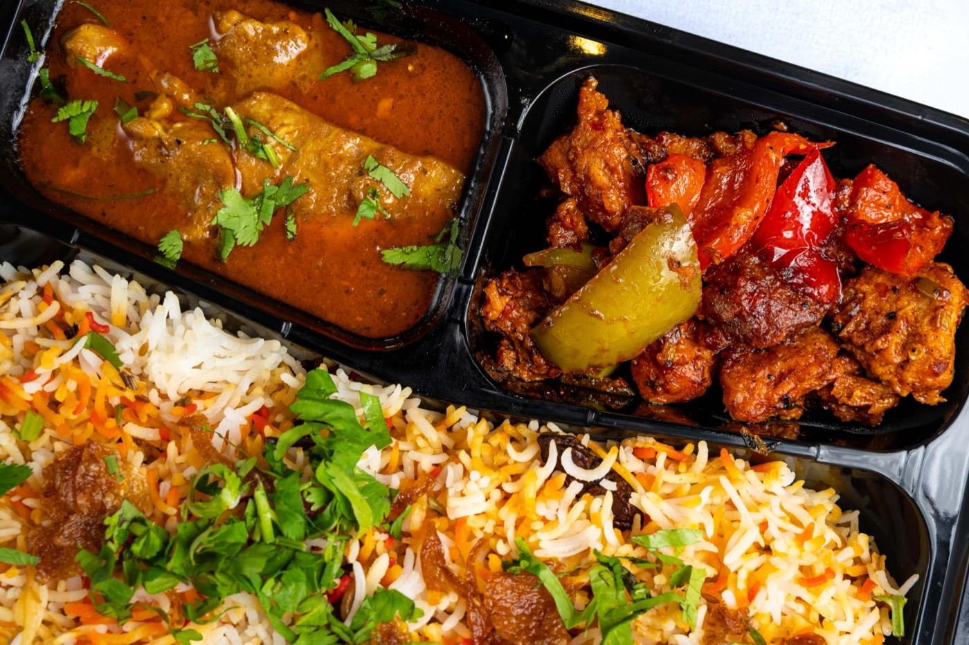 Close-up of Halal biryani with chicken curry and chilli chicken at India 101 in Irving, TX