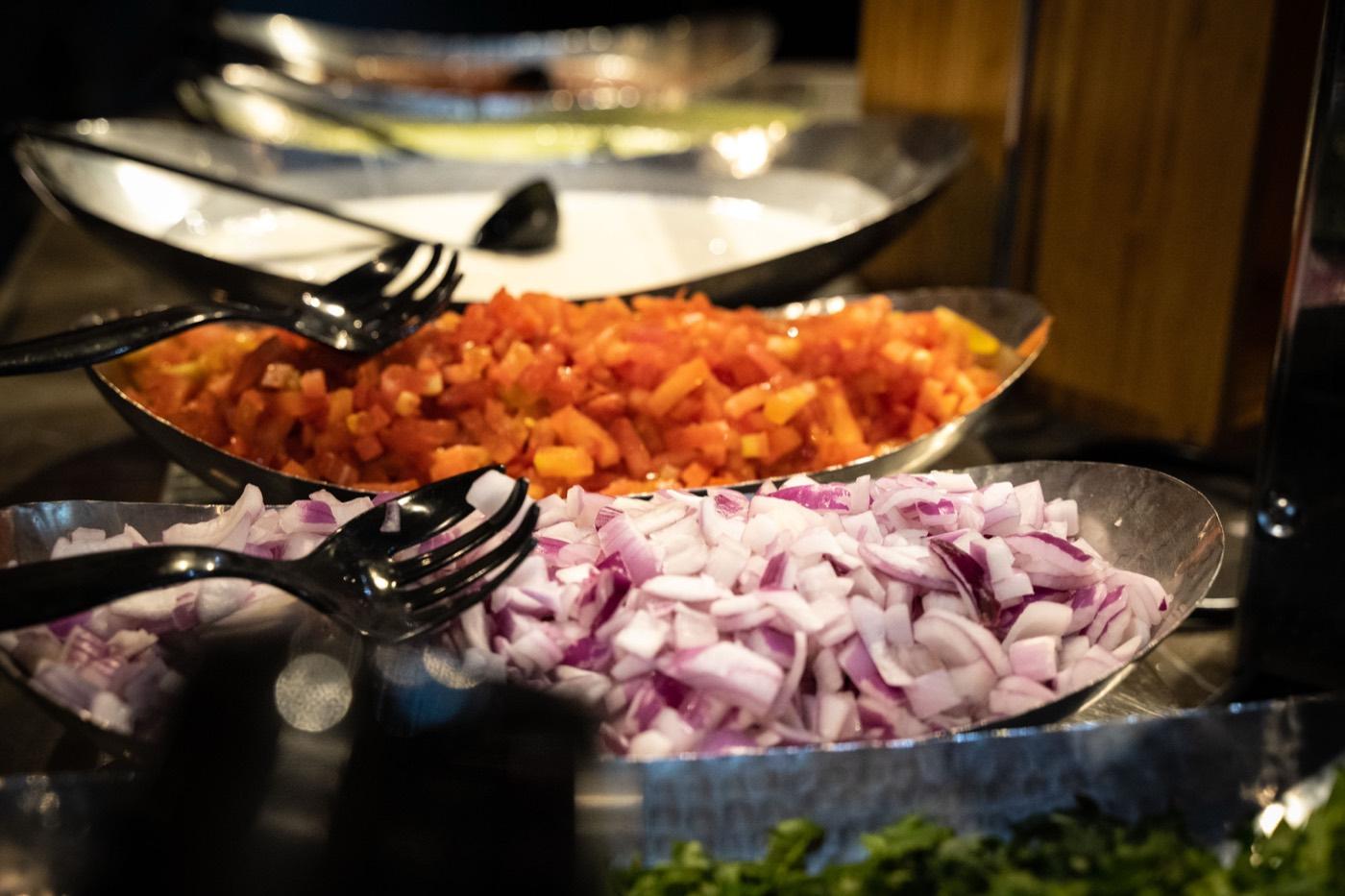 Chopped red onions and tomatoes in buffet boats at India 101 in Irving, TX