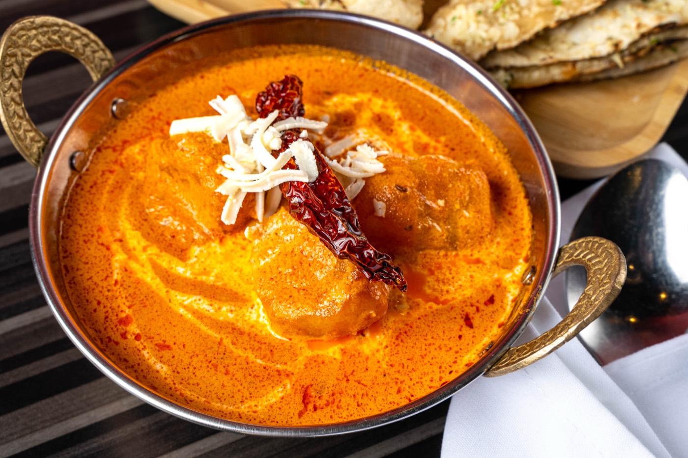 Close-up of Halal butter chicken in creamy tomato gravy at India 101 in Irving, TX