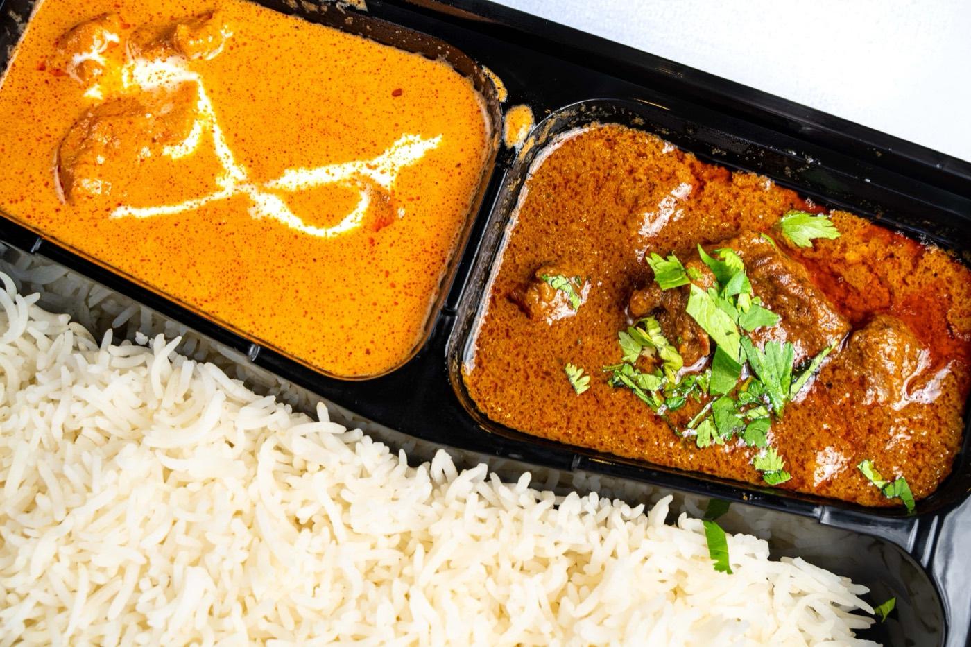 Close-up of Halal butter chicken and goat curry with basmati rice at India 101 in Irving, TX