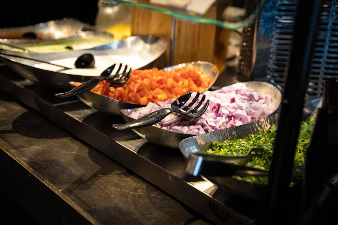 Buffet boats of chopped tomatoes, red onions and cilantro at India 101 in Irving, TX