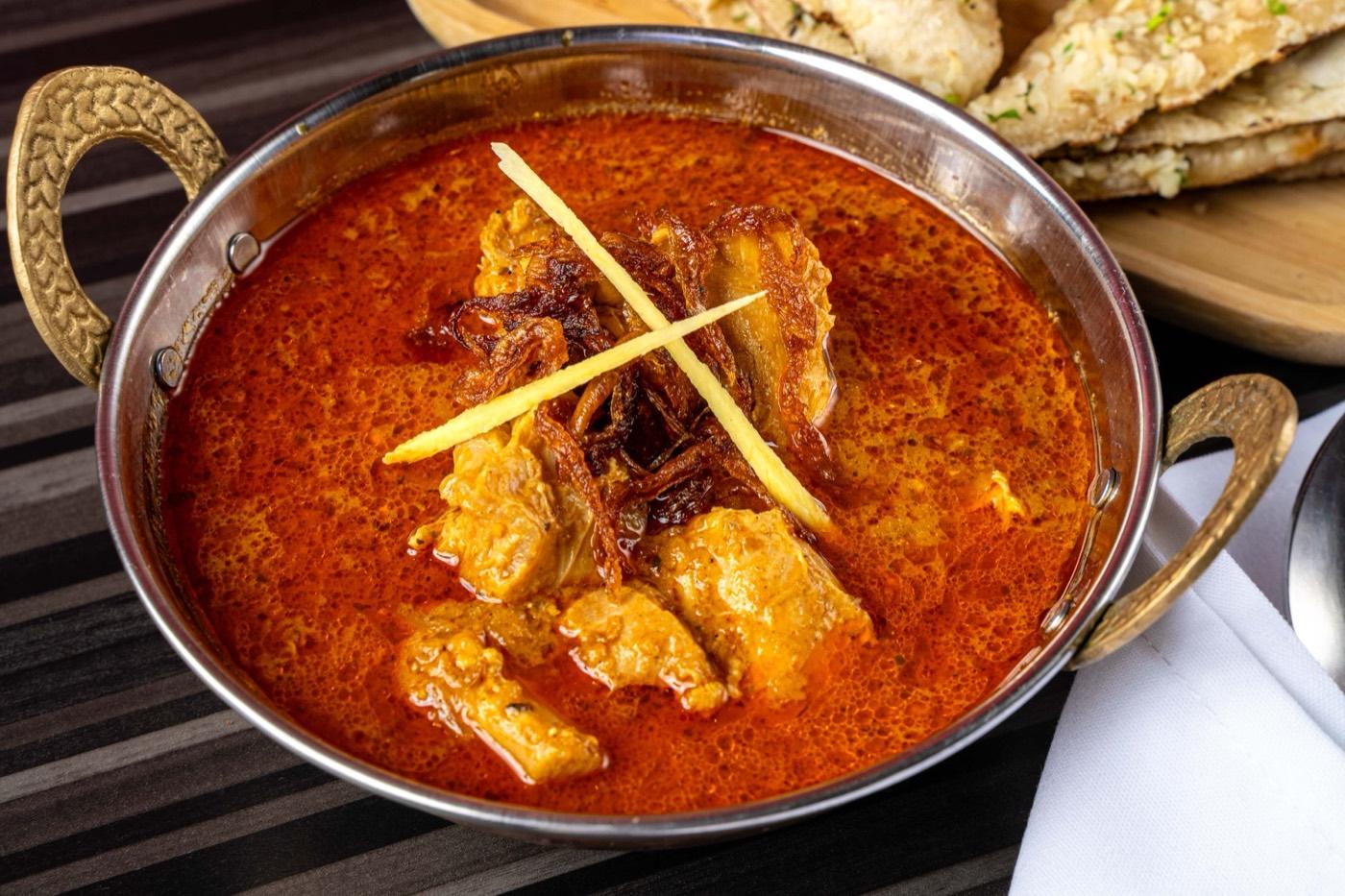 Halal chicken curry in a karahi with fried onions and ginger at India 101 in Irving, TX