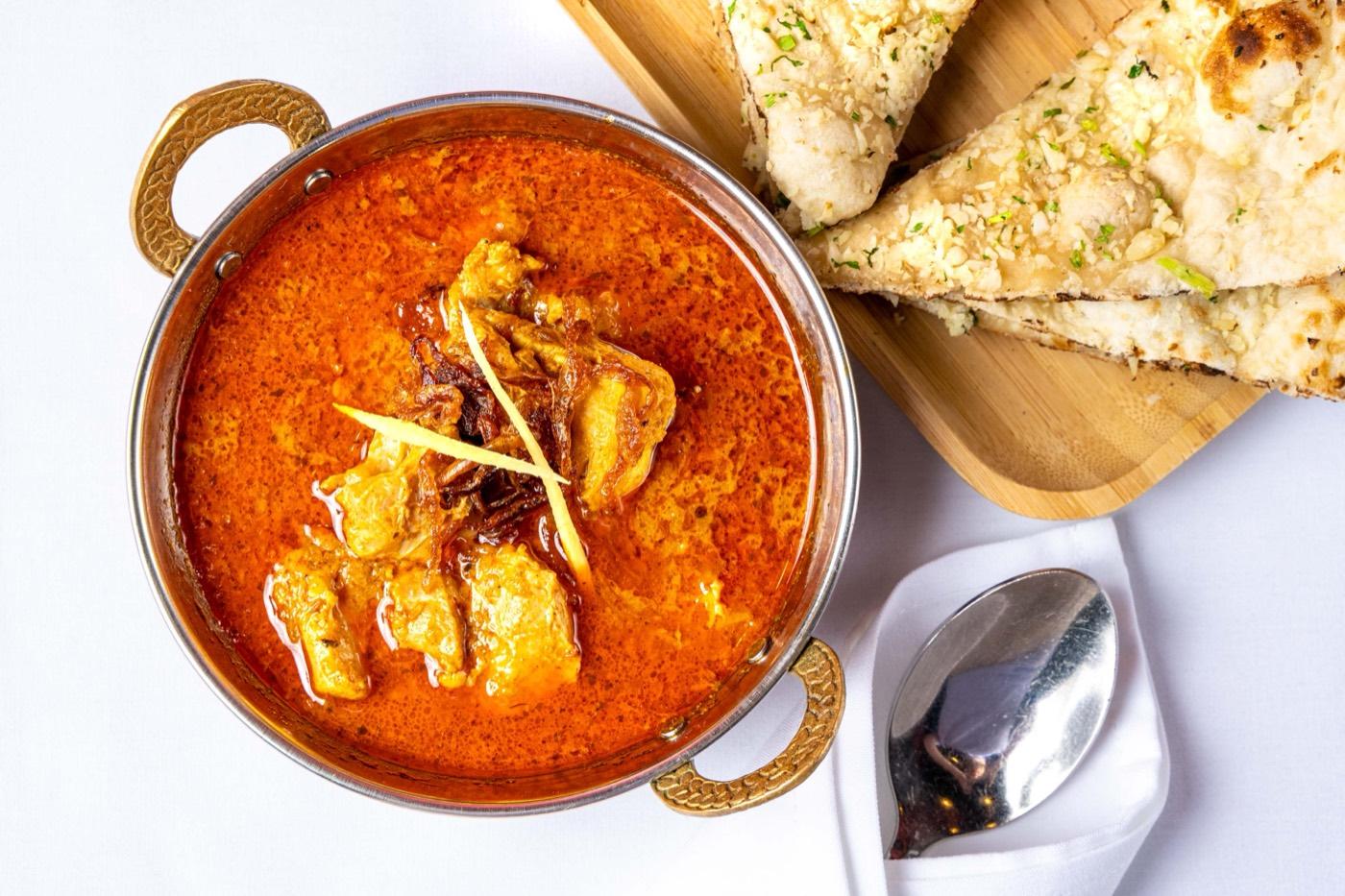 Halal chicken masala in a spiced red gravy with garlic naan at India 101 in Irving, TX