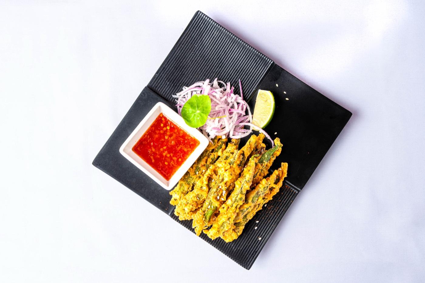 Top-down crispy fried okra with sweet chili sauce and onions at India 101 in Irving, TX