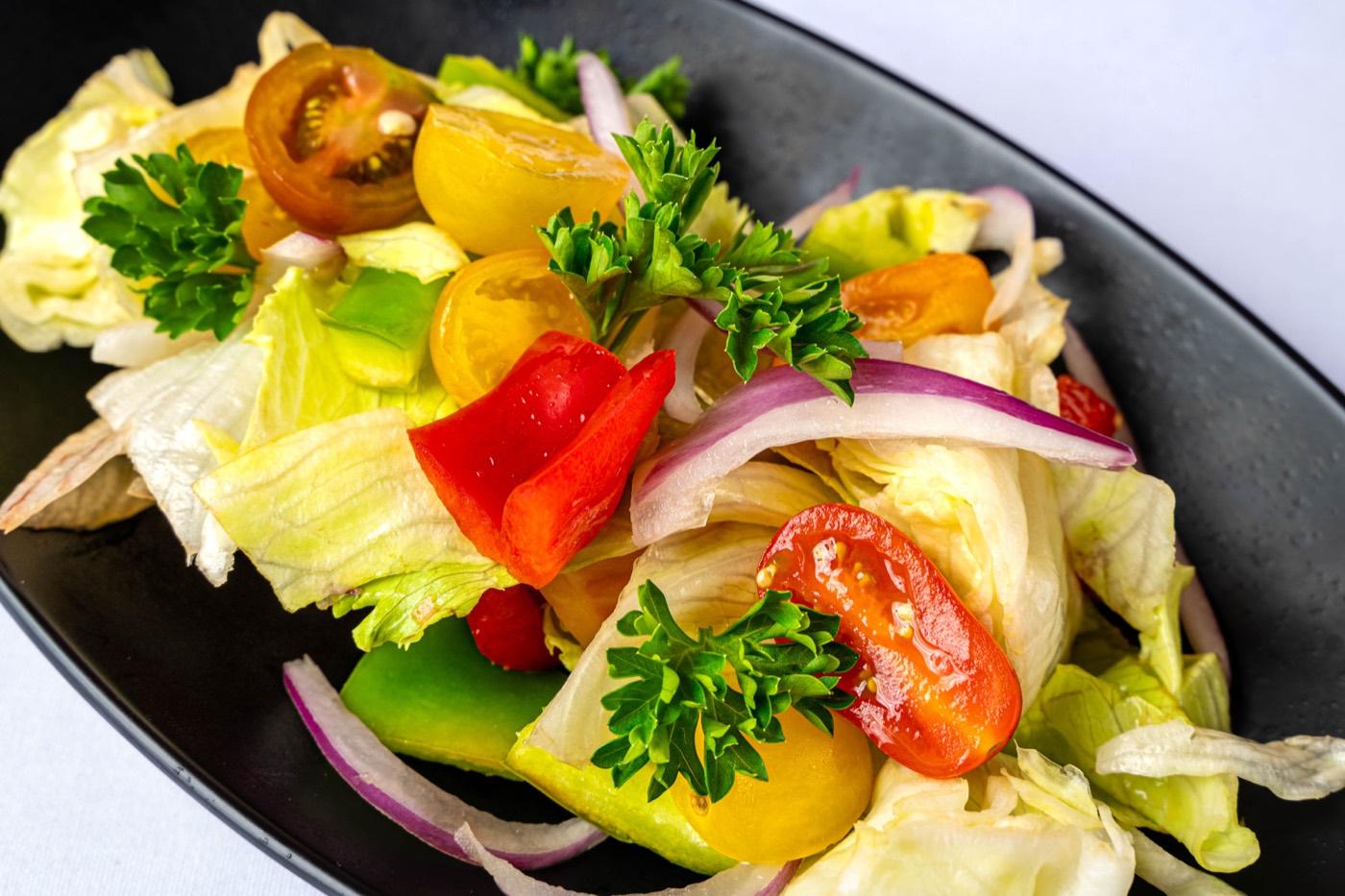 Close-up of crisp garden salad with lettuce, cherry tomatoes and peppers at India 101 in Irving, TX