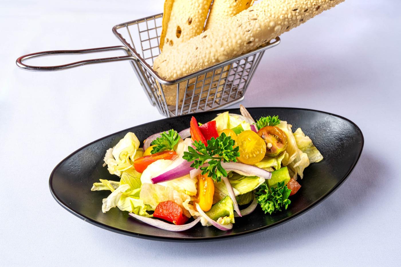 Fresh garden salad with cherry tomatoes served with masala papad