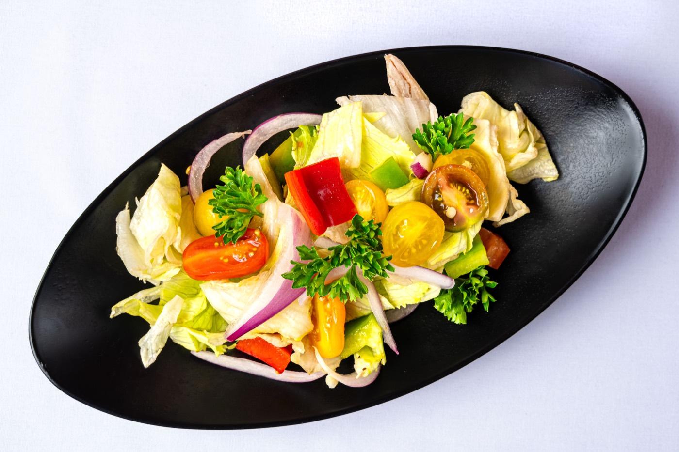 Fresh vegetarian garden salad with lettuce, tomatoes, peppers and red onion at India 101 in Irving, TX