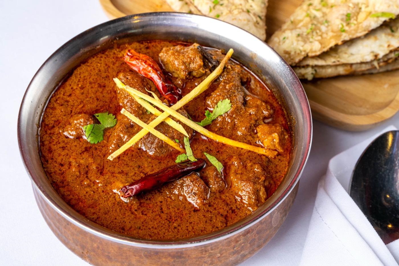 Close-up of Halal goat curry with ginger julienne and dried chilies at India 101 in Irving, TX