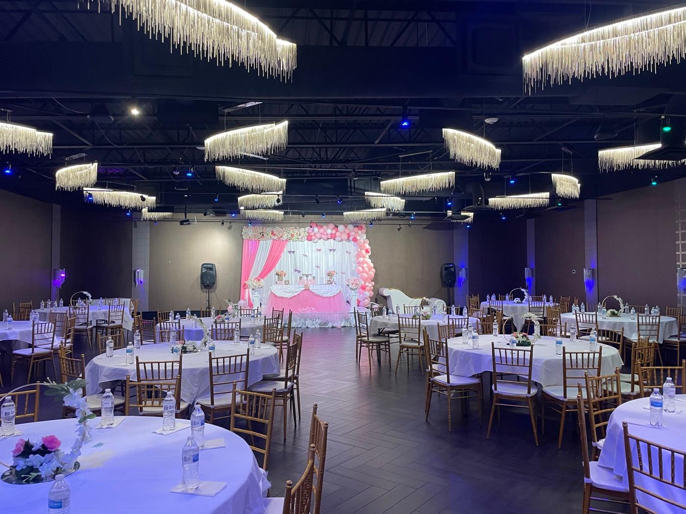 Grand ballroom set with pink backdrop and balloon arch at India 101 banquet hall in Irving, TX