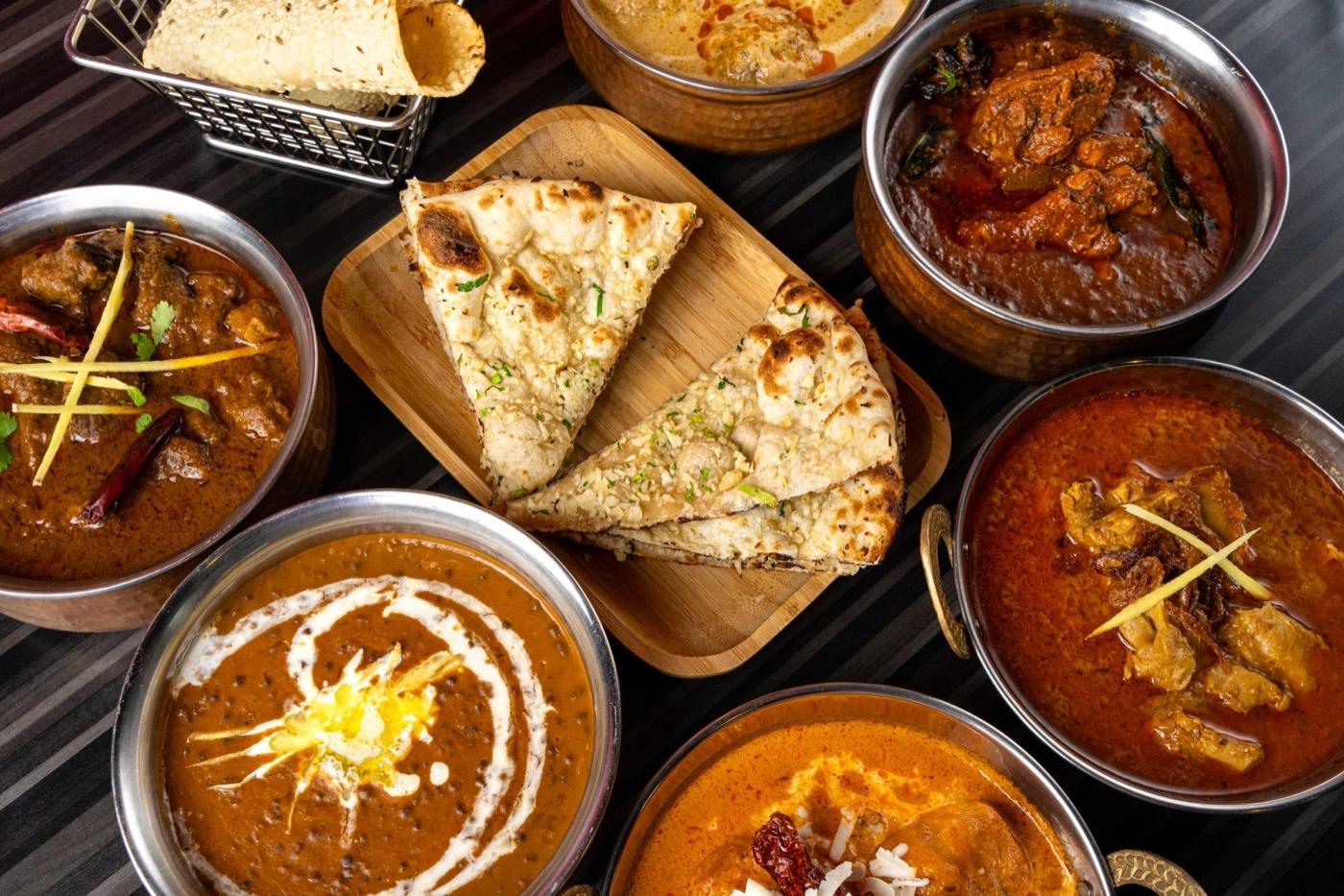 Overhead of Halal North Indian curries with dal makhani, butter chicken and naan at India 101 in Irving, TX