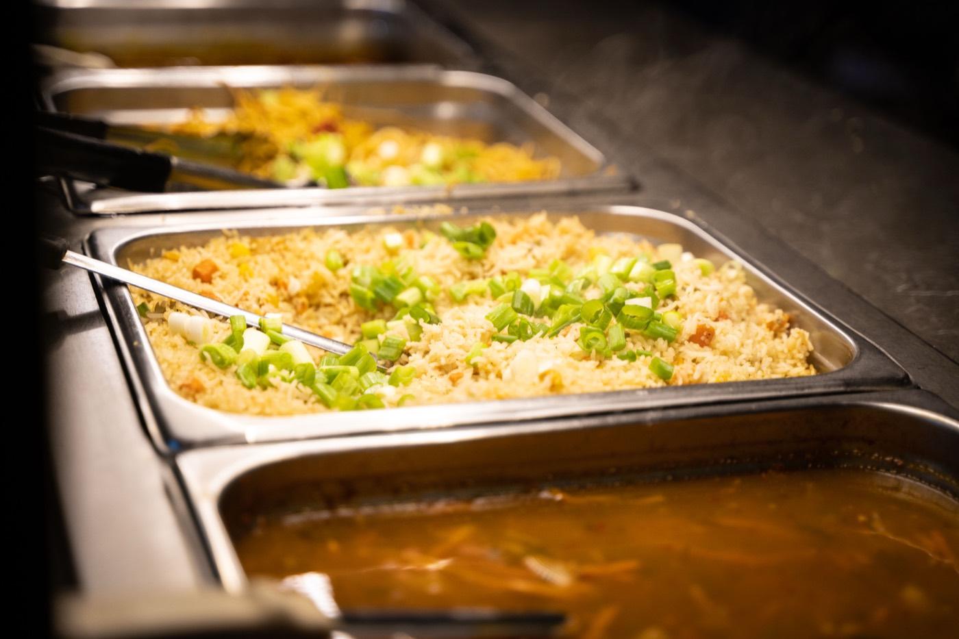 Buffet trays of Indo-Chinese vegetable fried rice topped with scallions at India 101 in Irving, TX