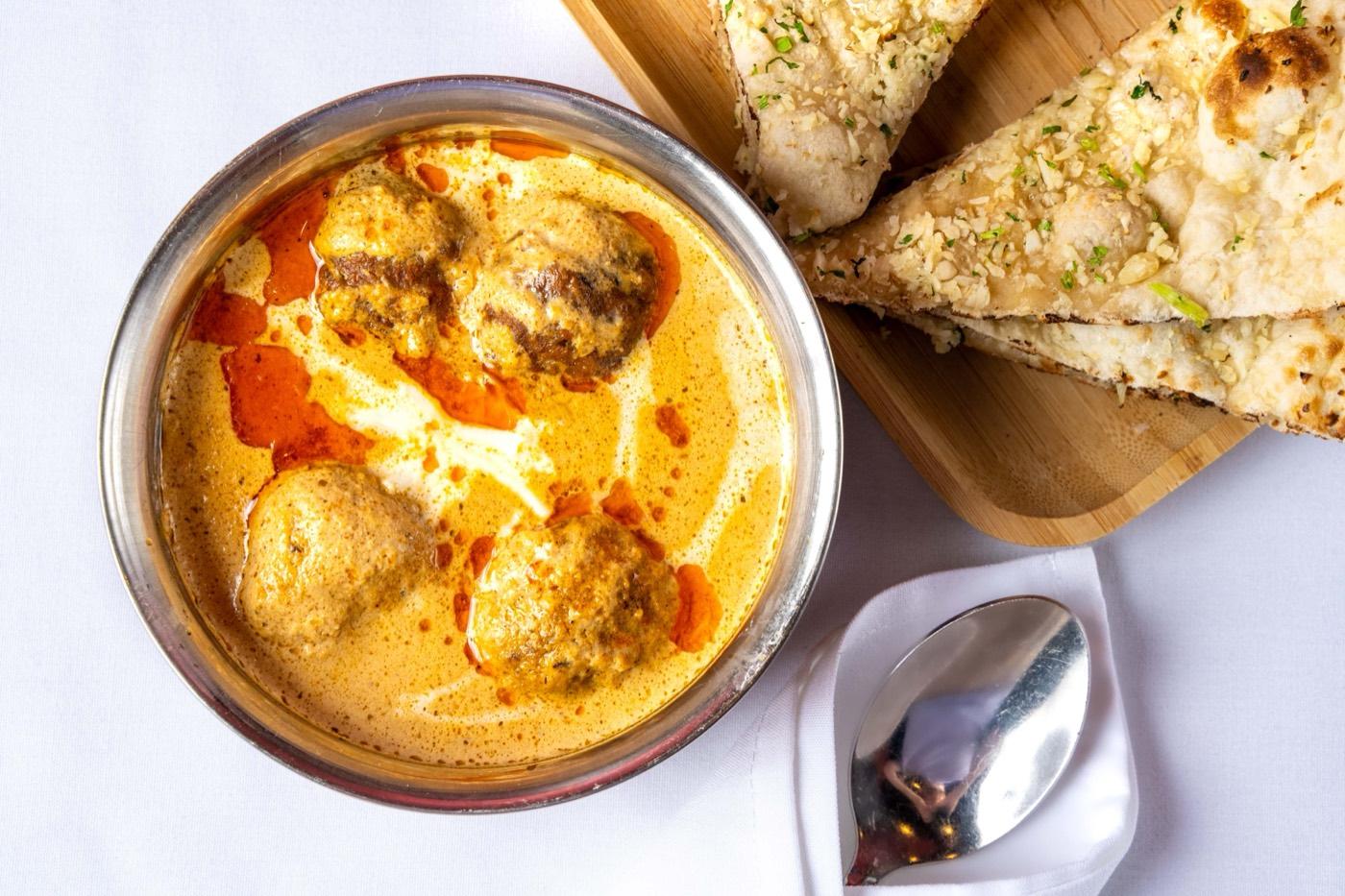 Malai kofta dumplings in creamy gravy with garlic naan at India 101 in Irving, TX