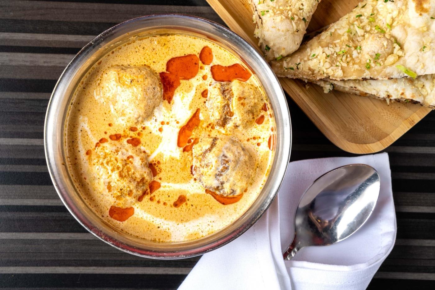 Malai kofta dumplings in creamy gravy with naan at India 101 in Irving, TX