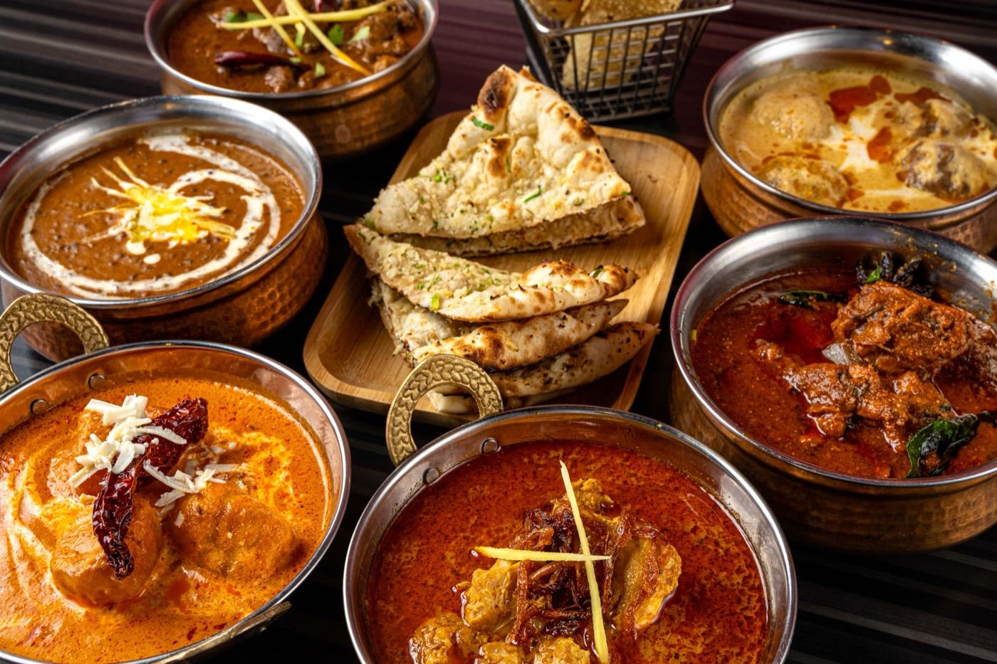 Copper bowls of North Indian curries with dal makhani and garlic naan at India 101 in Irving, TX