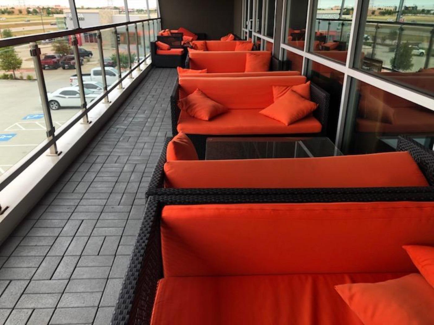 Outdoor balcony lounge with orange cushioned seating at India 101 event venue in Irving, TX