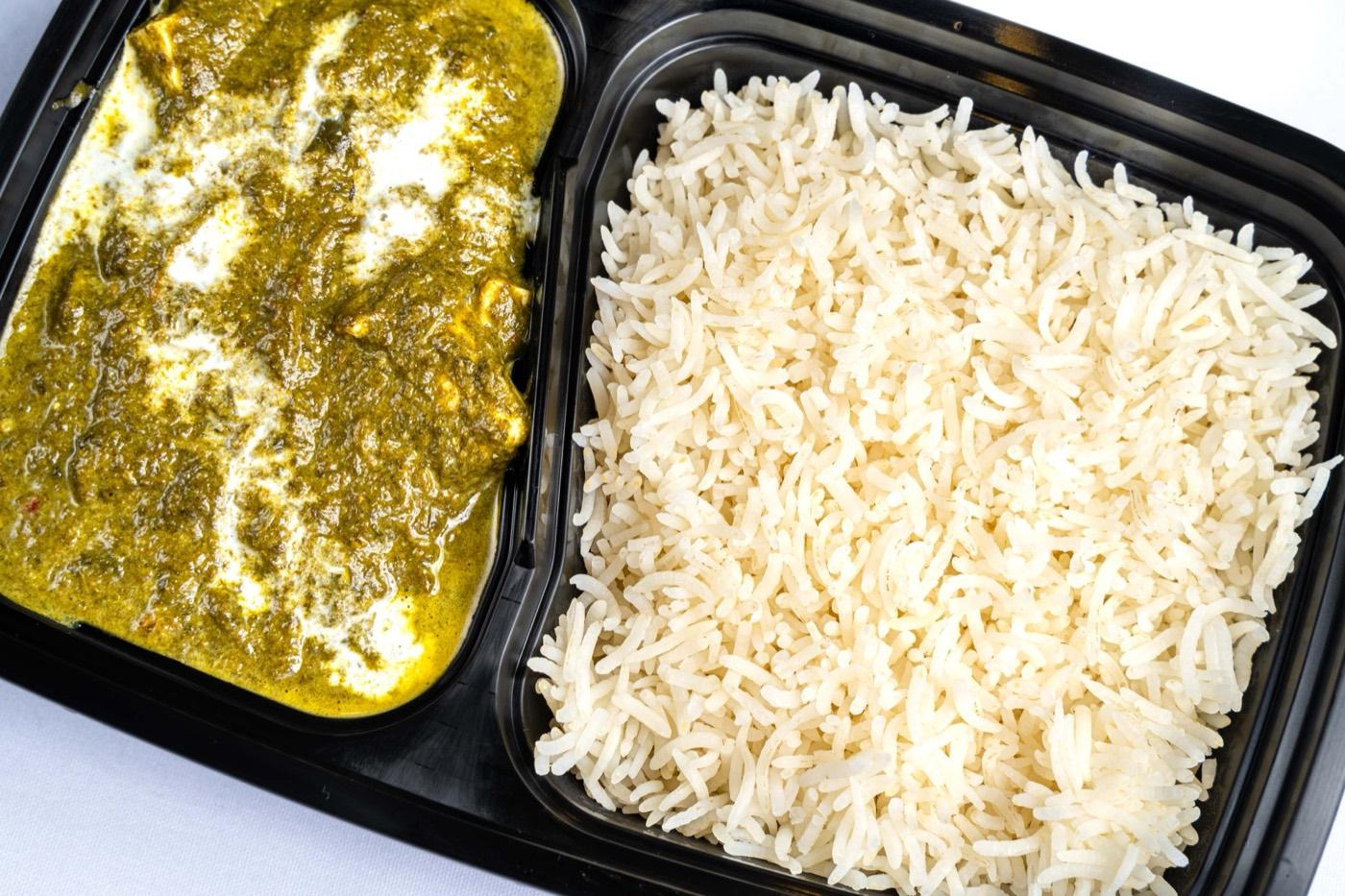 Takeout container of palak paneer with basmati rice