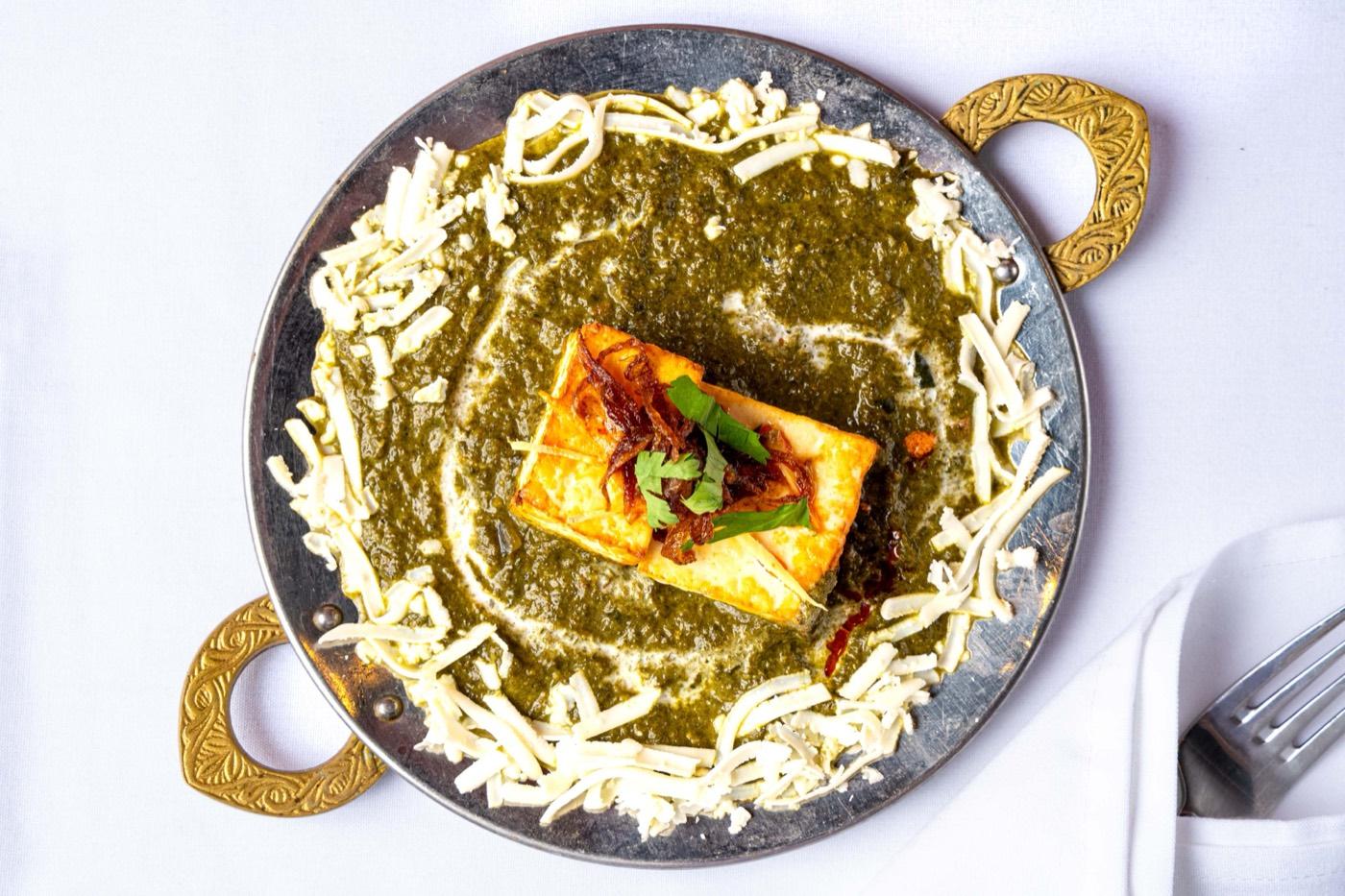 Top-down palak paneer in spinach gravy with grated cheese border at India 101 in Irving, TX