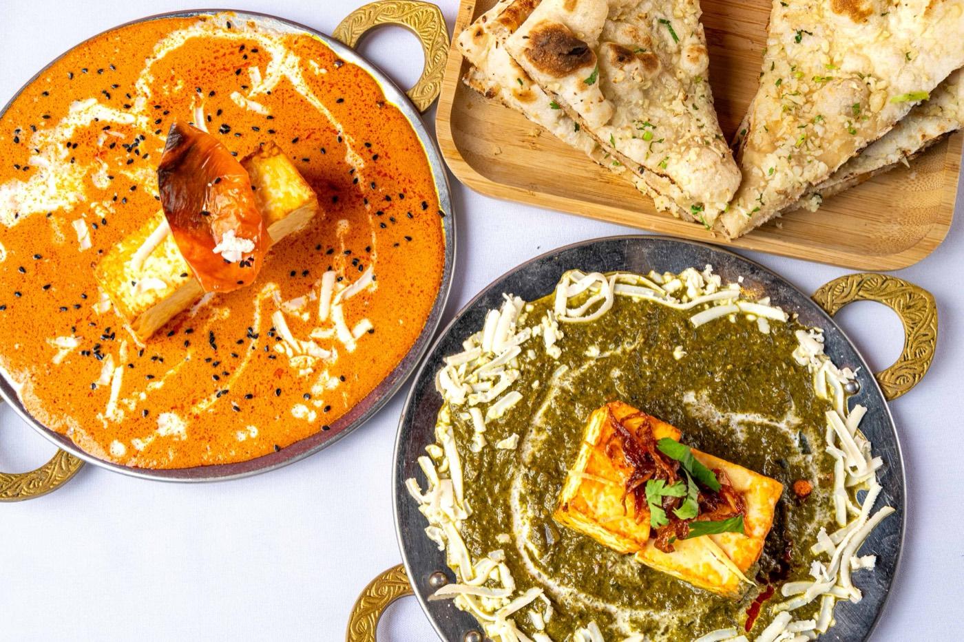 Orange makhani paneer, green palak paneer and naan spread at India 101 in Irving, TX