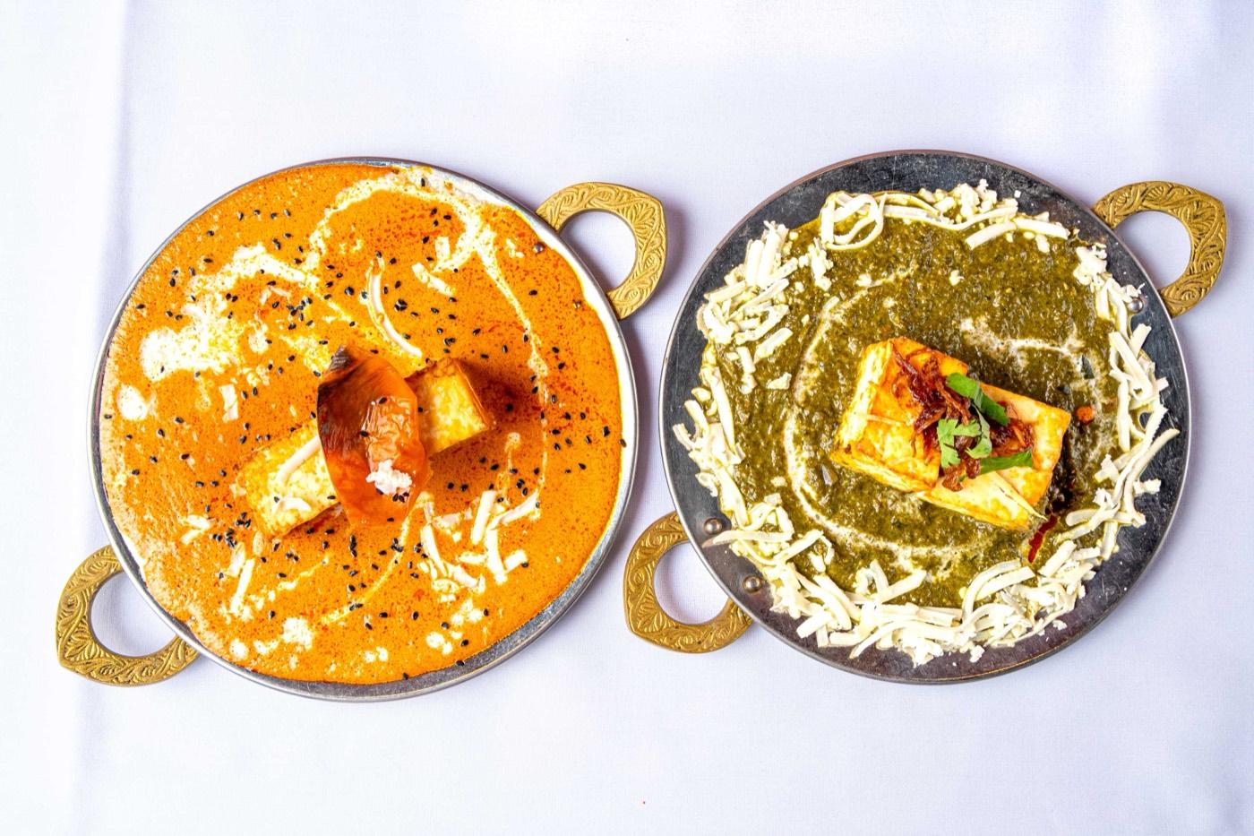 Orange makhani paneer and green palak paneer karahis with naan at India 101 in Irving, TX
