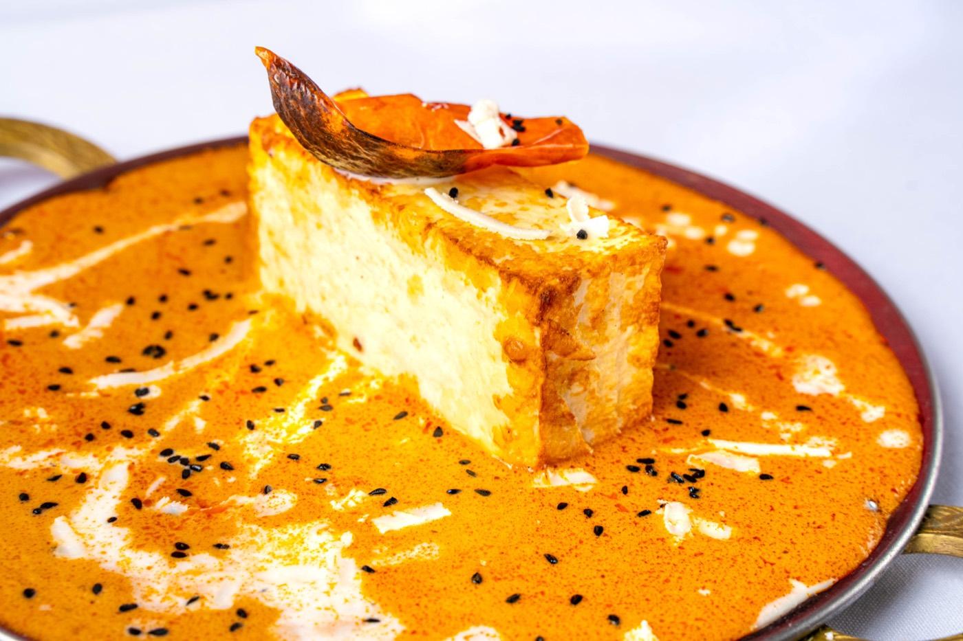 Top-down paneer in creamy orange gravy with nigella seeds at India 101 in Irving, TX