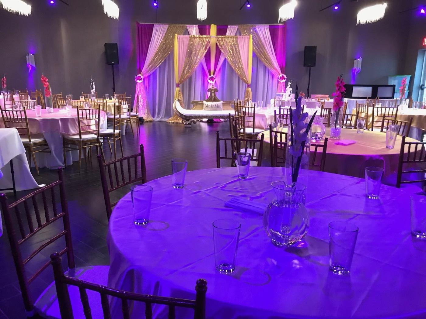 Pink and gold wedding stage with Mr and Mrs seating and purple lighting at India 101 banquet hall in Irving, TX