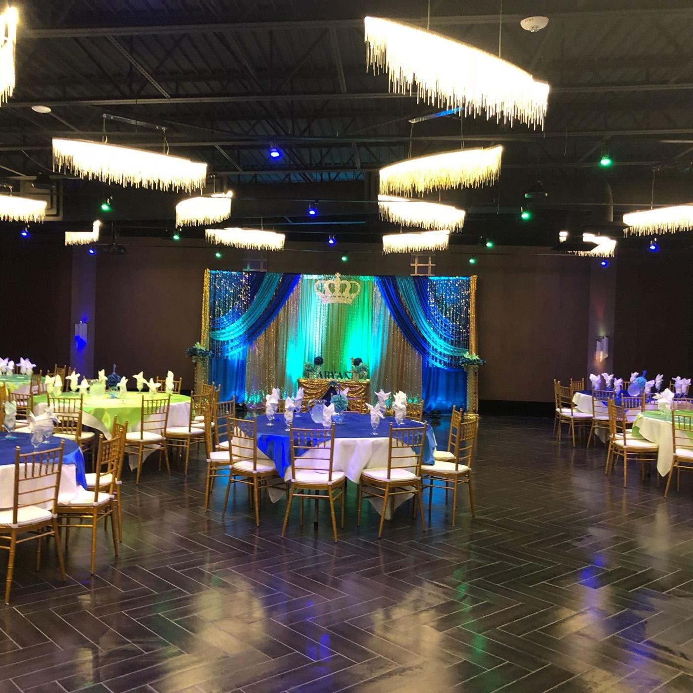 Royal blue and green draped stage with crown backdrop at India 101 banquet hall in Irving, TX