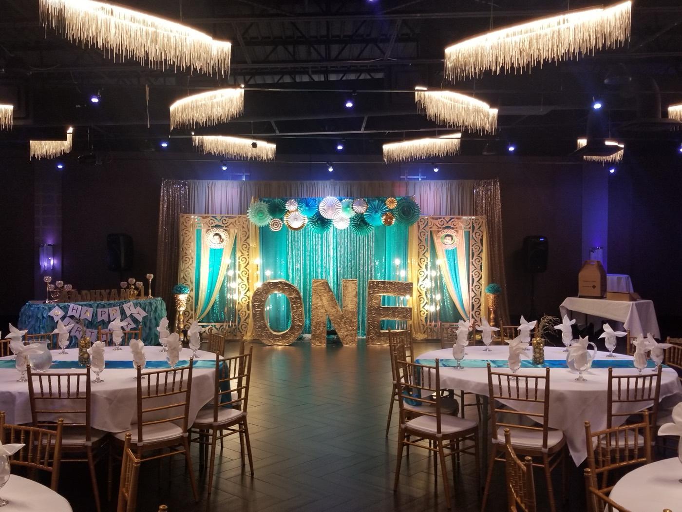 Teal and gold first birthday party setup with ONE marquee backdrop at India 101 banquet hall in Irving, TX