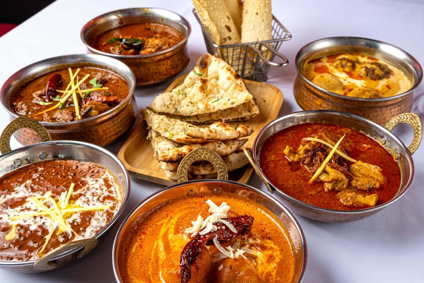 Spread of North Indian curries with naan and papadum basket at India 101 in Irving, TX