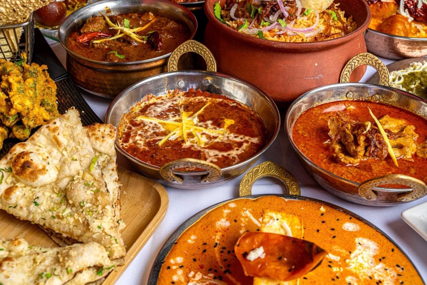 Close-up spread of Halal Indian curries, naan, biryani and paneer at India 101 in Irving, TX