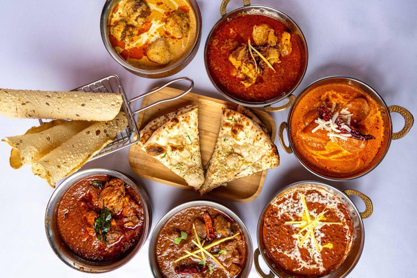 Assortment of Halal North Indian curries with naan and papadum at India 101 in Irving, TX